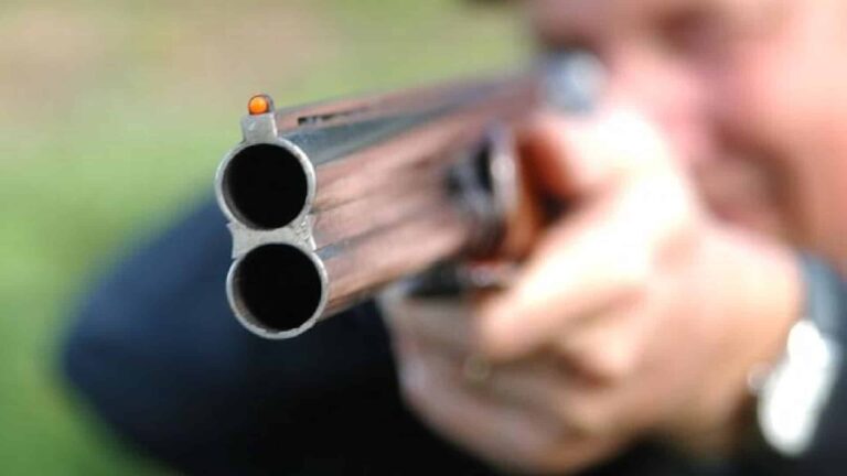 Un homme pointant son fusil de chasse