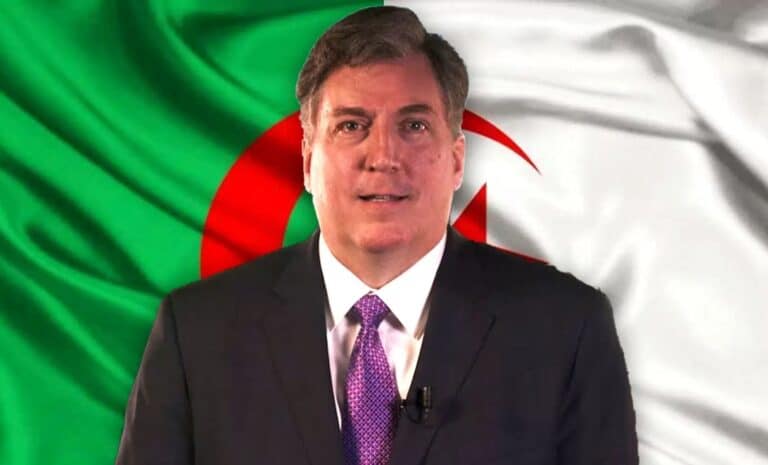 John Desrocher devant le drapeau de l'Algérie