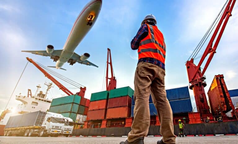 Port avec des conteneurs et un avion passant au-dessus
