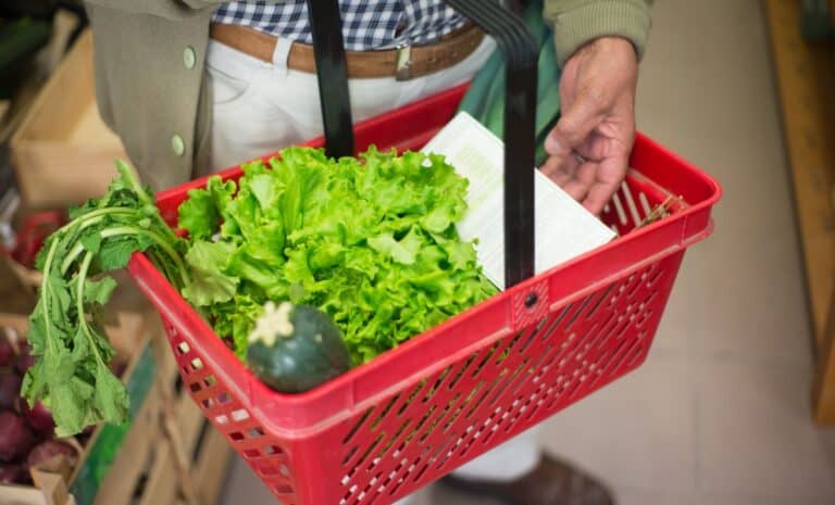 Personne portant un panier dans un supermarché