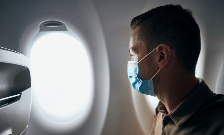 Homme portant un masque chirurgical dans un avion Homme portant un masque chirurgical dans un avion